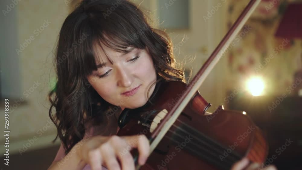 Portrait of attractive violinist playing the melody on viola in bedroom Portrait of attractive violinist playing the melody on viola in bedroom