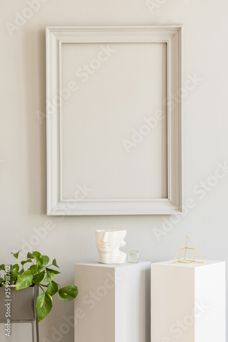 Minimalistic and design home decor with mock up grey poster frame and white pedestals with stylish accessories and platns. Eclectic and modern room interior. Template. Blank. Real photo. © FollowTheFlow