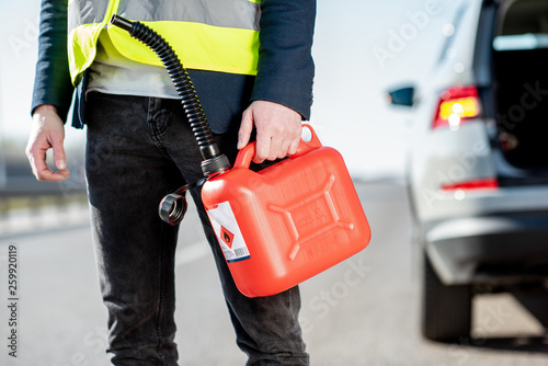 Cuadro en lienzo Man with refuel canister on the roadside with his car on the background, close-u