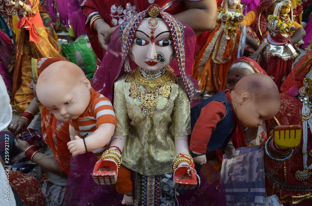 Gangaur gaur statue with red saree and ornaments with two babies on both hand