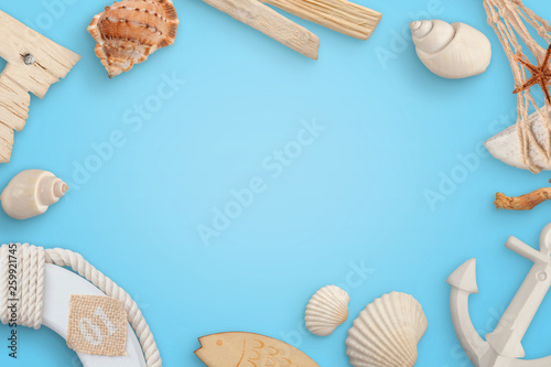 Summer time, sailor concept with sea shells, boat, anchor, lifebelt on blue backround. Copy space in the middle.