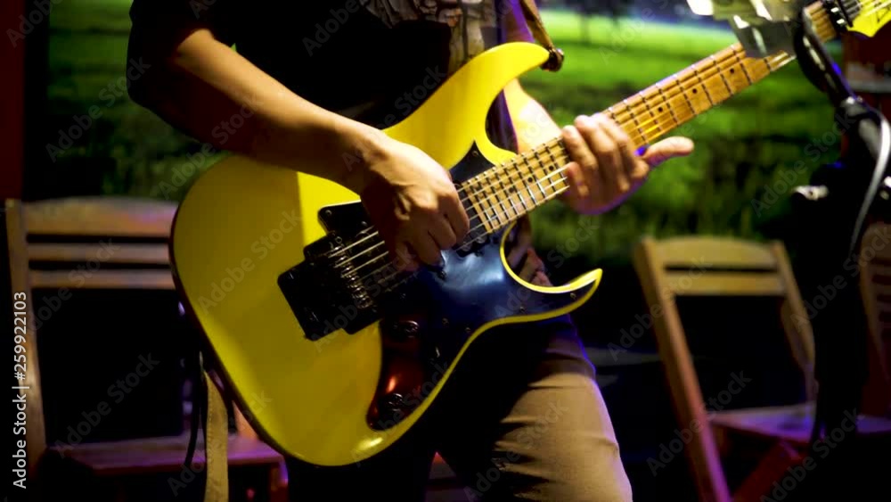 Musicians hands, playing guitar, performing live at night in partying events Musicians hands, playing guitar, performing live at night in partying events