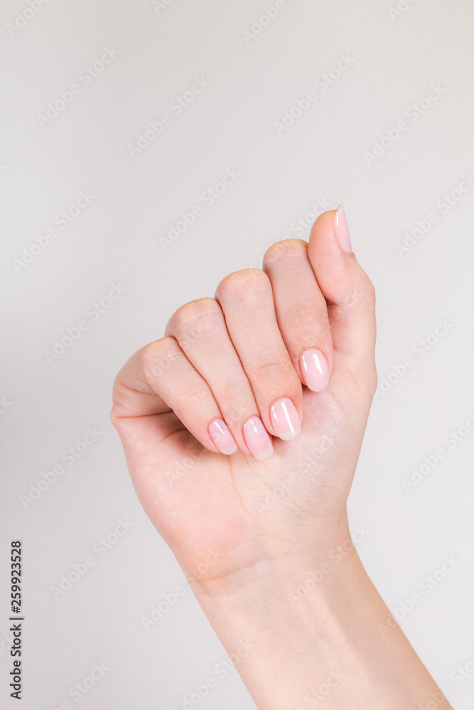 Closeup view of single female hand isolated on white background. Nails manicured with pink pastel gel polish. Vertical color photography. Closeup view of single female hand isolated on white background. Nails manicured with pink pastel gel polish. Vertical color photography.