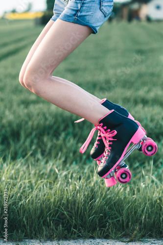 Teenage girl having fun rollerskating, jumping, spending time outdoors
