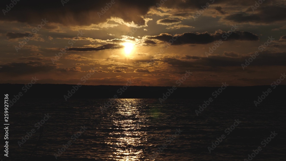 light breeze on surface of water. beautiful sunset over lake, the trail of the sun glistens on water. brilliant water in morning at sunrise. beautiful waves on water sparkle in rays of the sun.