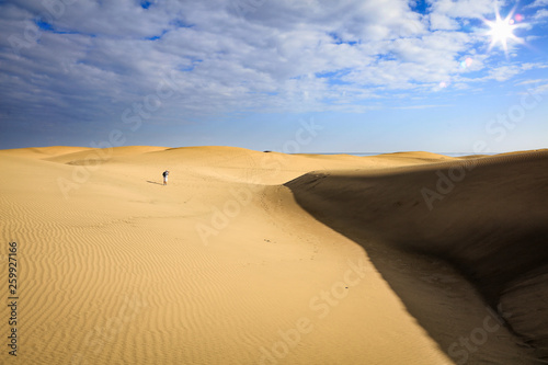 Summer background of sand on beach and blue sky with sun light. Free space for your decoration. 
