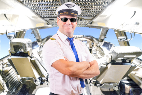 Adult pilot with sunglasses, background of cockpit plane. Captain of air plane with white shirt uniform standing in cabin of aircraft. photo