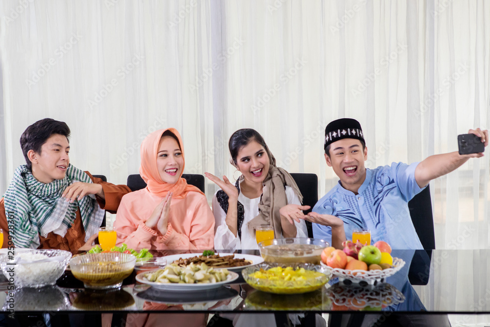 Young Muslim people take picture before eating Young Muslim people take picture before eating