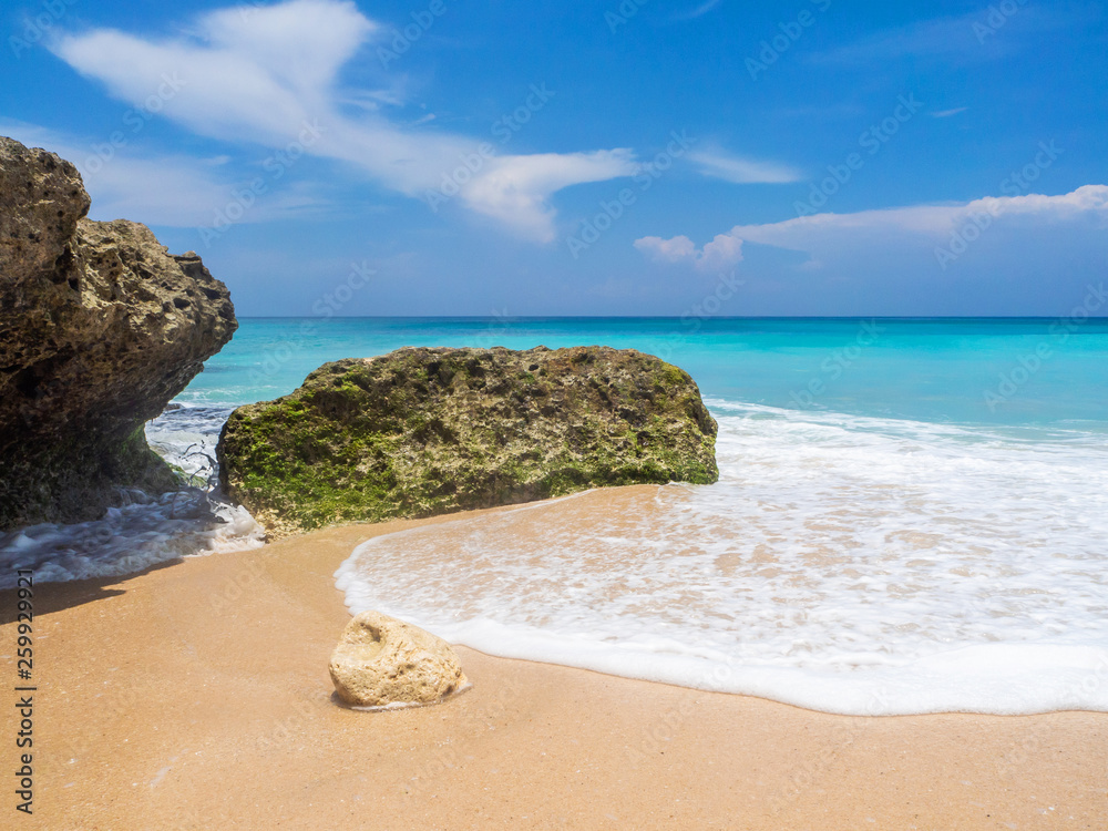 Turquoise waves crash against stones with splashes. Bali. Turquoise waves crash against stones with splashes. Bali.