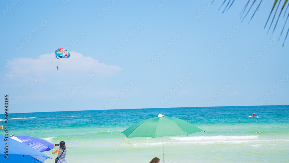 Tropical beach background with beautiful blue sea and parachute  , crystal clear sea and white sand with palms