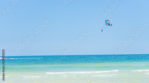 Tropical beach background with beautiful blue sea and parachute , crystal clear sea and white sand with palms