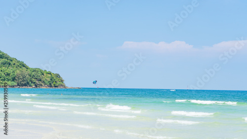 Tropical beach background with beautiful blue sea and parachute  , crystal clear sea and white sand with palms © Hryhorii