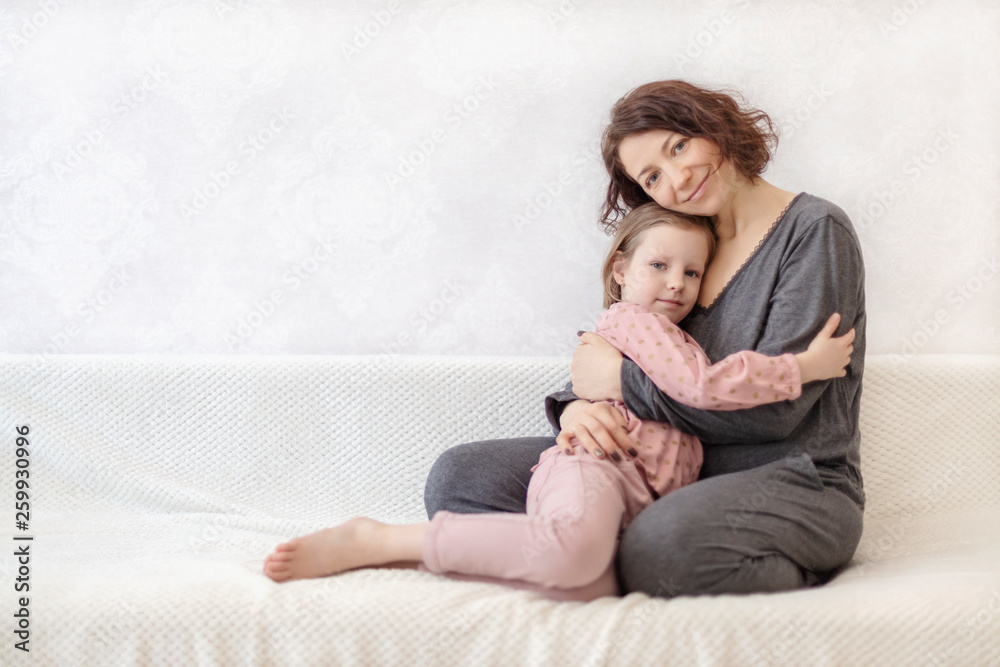 Young woman with her daughter are resting on the sofa. Young woman with her daughter are resting on the sofa.