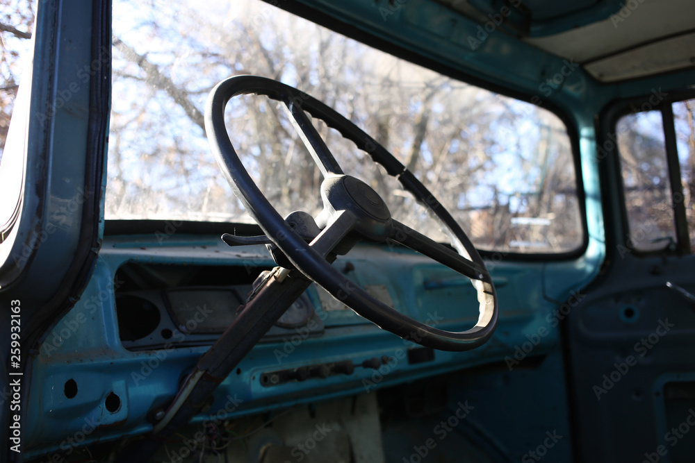Big steering wheel of an old truck with a metal salon that is not safe and not comfortable.