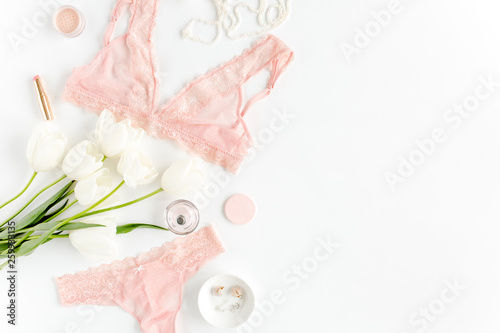 Flat lay set of sexy, lacy, pink lingerie, accessories on white background. Top view.
