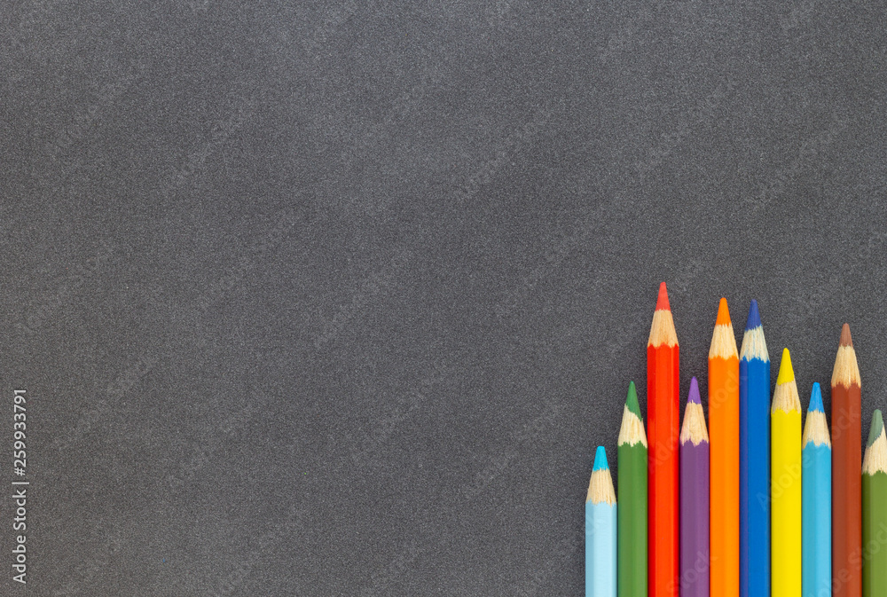 Colored pencils on dark background top view Colored pencils on dark background top view