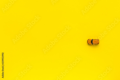 Little Yellow toy car on a yellow background. Free space for text