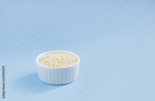 rice in a plate on top, on a blue background, copy space