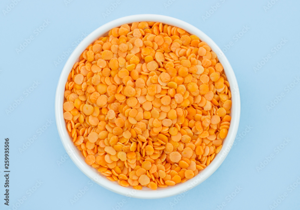 lentils in a plate on top, on a blue background, copy space