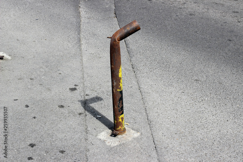 Damaged metal no parking pole post city town street pavement sidewalk