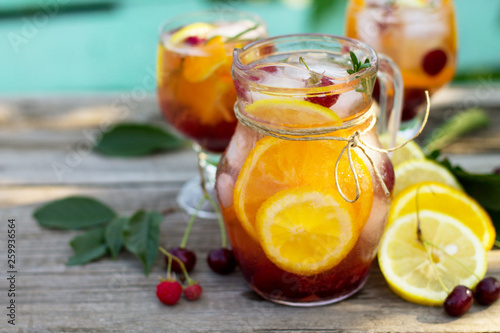 Homemade refreshing drink. Wine sangria or punch with fruits in glasses, cocktails with fresh fruits, berries and rosemary on a wooden rustic table. Copy space.