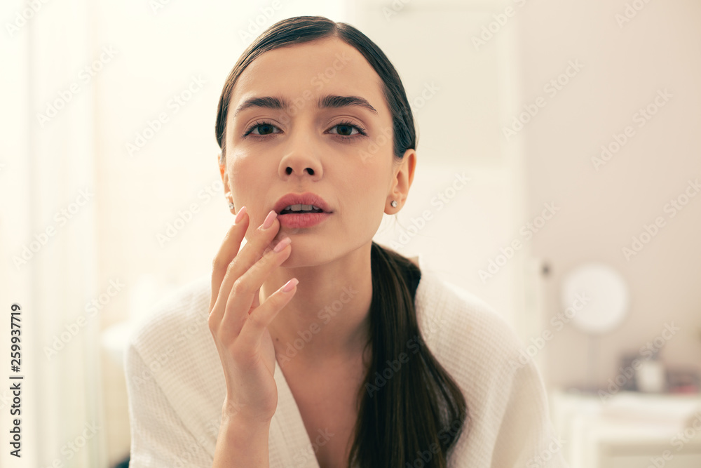 Thoughtful woman touching her lips and looking away Thoughtful woman touching her lips and looking away