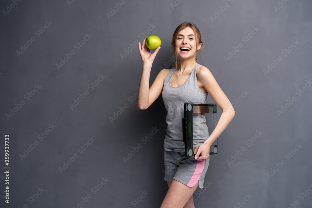 Healthy woman stands with the scales and green apple. Healthy eating concept. Healthy woman stands with the scales and green apple. Healthy eating concept.
