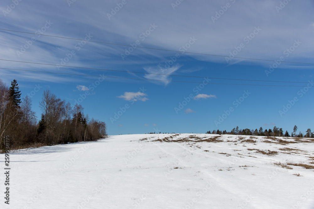 spring landscape, melting snow on the road and field in the countryside spring landscape, melting snow on the road and field in the countryside