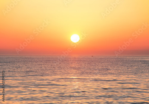 Black Sea at sunset. Large yellow sun under the sea surface. Sochi, Russia.