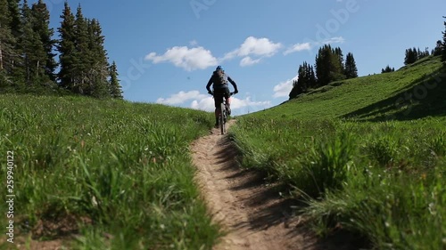 Mountain Biker Rides Up Dirt Path