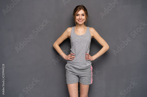fitness woman. Young sporty Caucasian female model isolated on gray background. © opolja