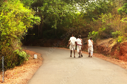 Three monks walking on the road. Gokarna, Karnataka, India.
