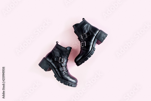 Black female boots on pink background. Flat lay, top view minimal background. Fashion blog or magazine concept. photo