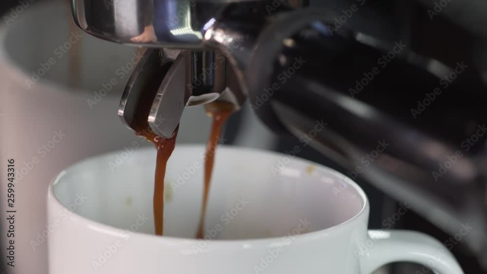 Espresso pouring to cup from coffee maker machine. Espresso pouring to cup from coffee maker machine.