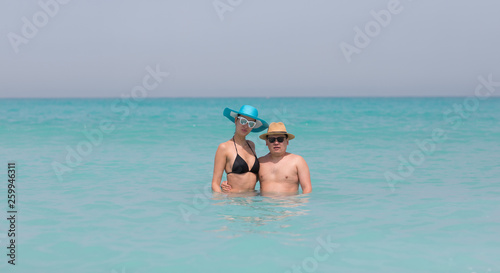 guy and girl are swimming on the beach