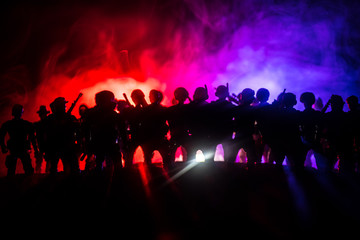 Anti-riot police give signal to be ready. Government power concept. Police in action. Smoke on a dark background with lights. Blue red flashing sirens.