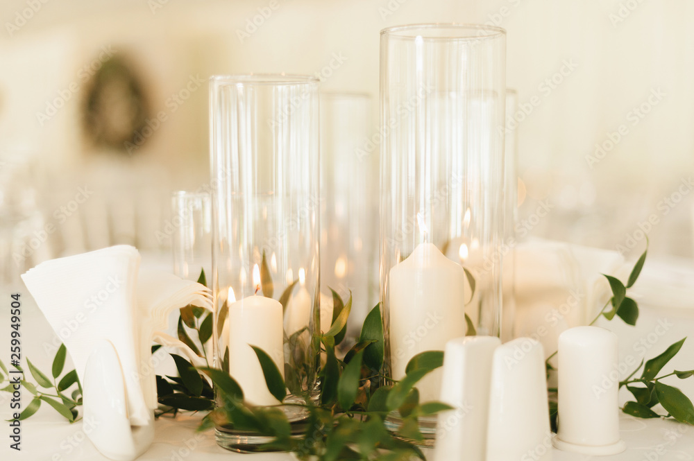 Photo of wedding candles decoration with leaves and glass