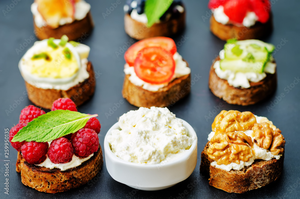 Ricotta and crostini appetizers with fillings on a black background