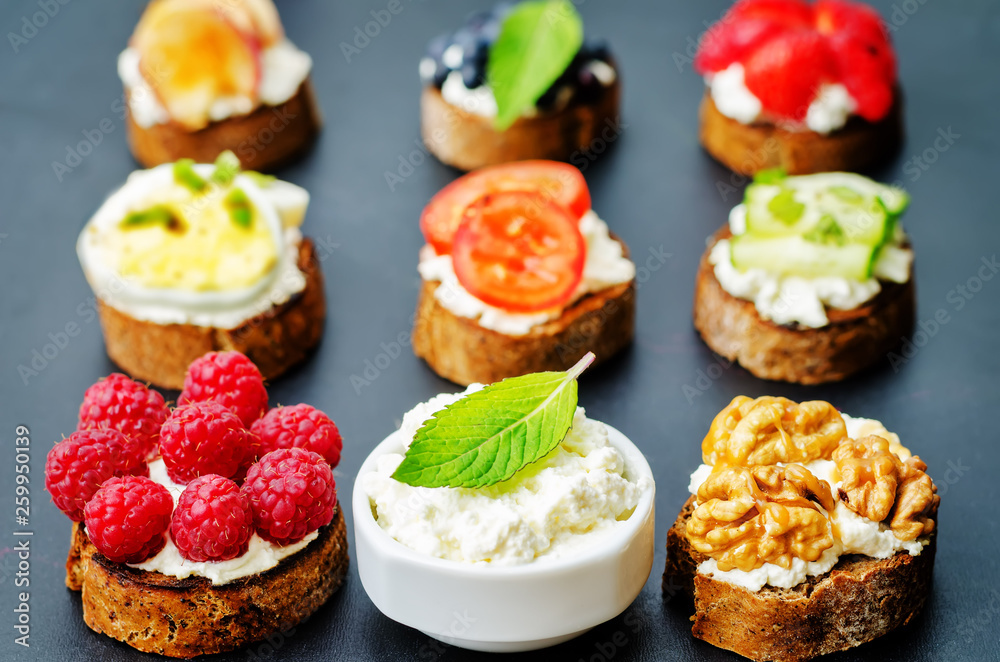 Ricotta and crostini appetizers with fillings on a black background Ricotta and crostini appetizers with fillings on a black background