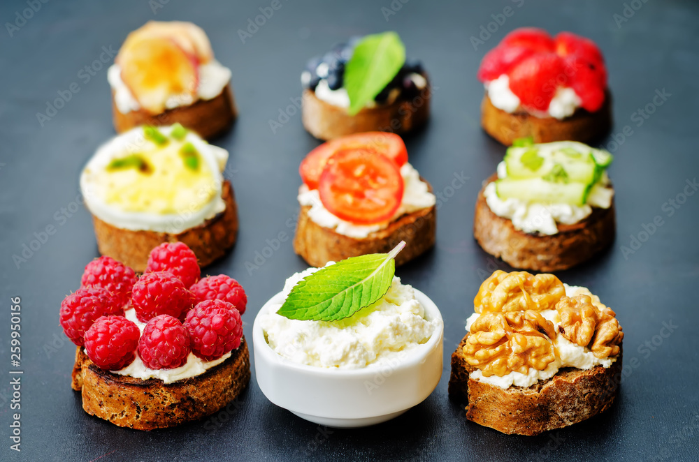 Ricotta and crostini appetizers with fillings on a black background Ricotta and crostini appetizers with fillings on a black background