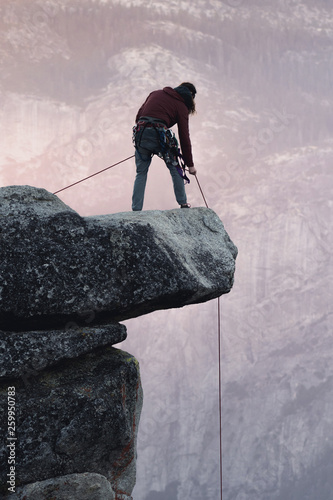 Man prepares to climb from Hanging Rock at sunset in Yosemite