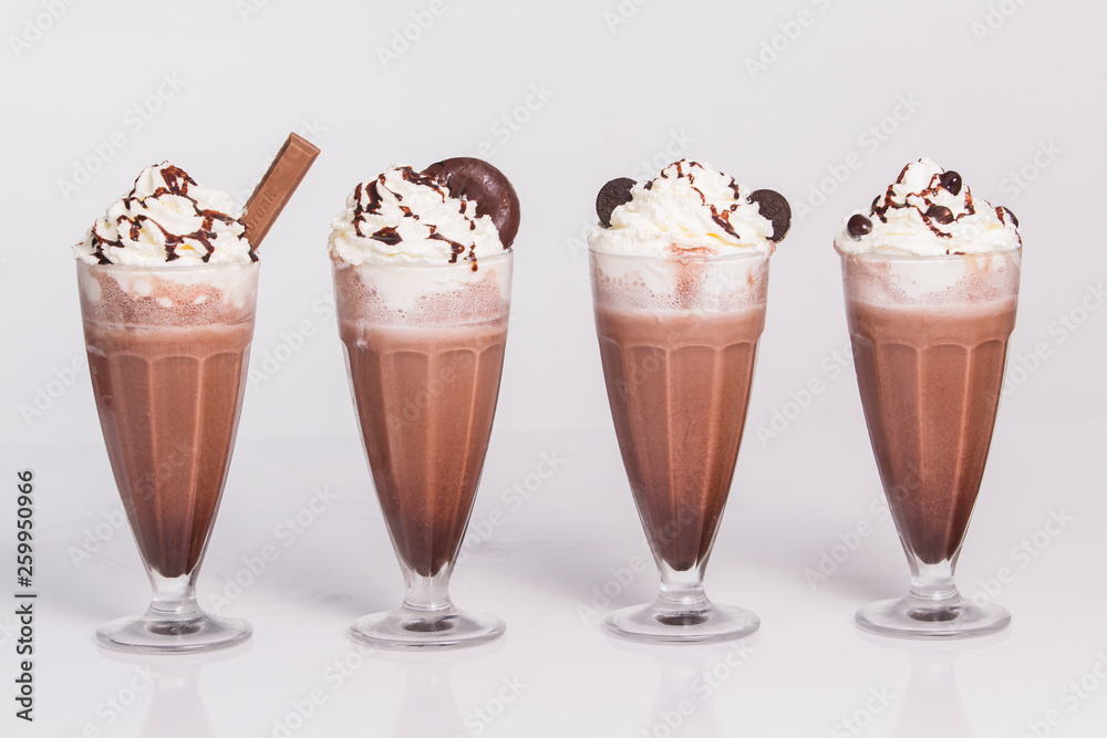 Hot chocolate with whipped cream in mugs isolated on white