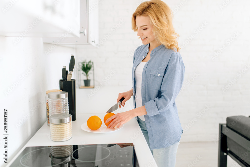 Woman preparing oranges, breakfast on the kitchen Woman preparing oranges, breakfast on the kitchen