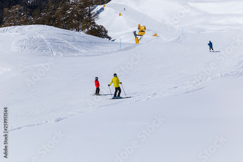 Skiers go down the mountain road