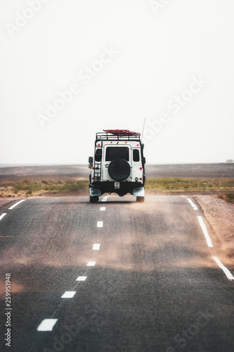 On the road to Merzouga, car travels the road to the Sahara desert of Morocco during a sandstorm. photo