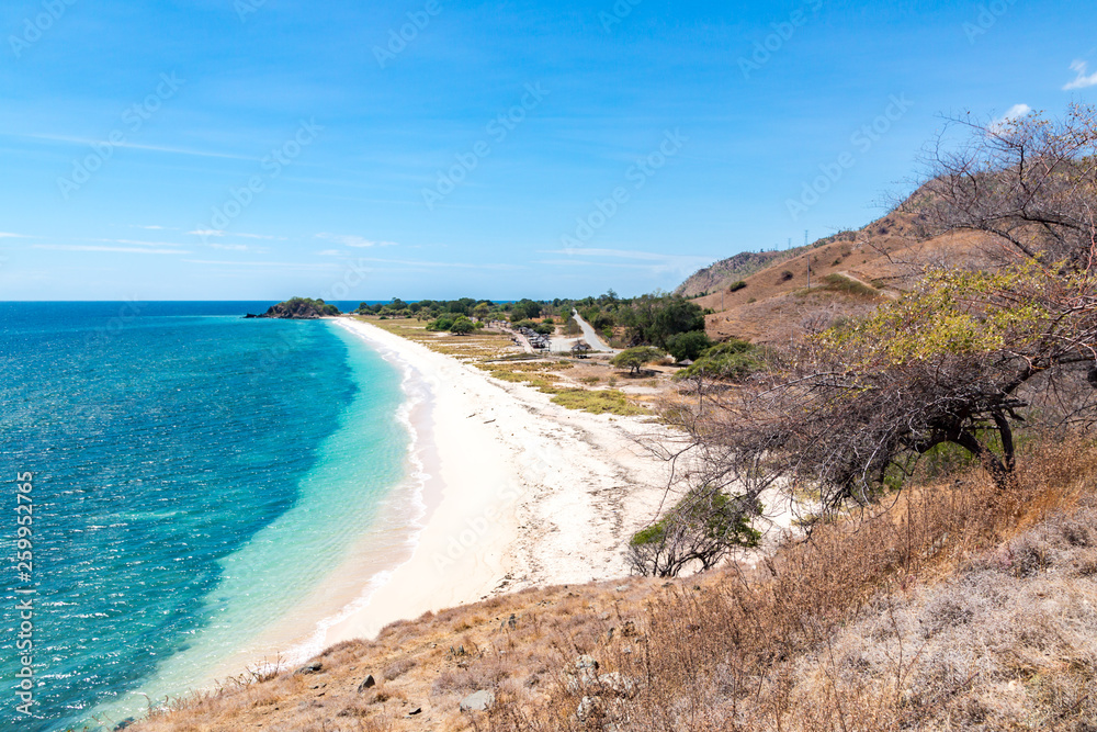 One dollar beach. Idillic yellow sandy beach of East Timor, Timor-Leste. Coastline with hills, mountains and dry savanna. Rural landscape and nature between Dili and Manatuto. Maritime Southeast Asia