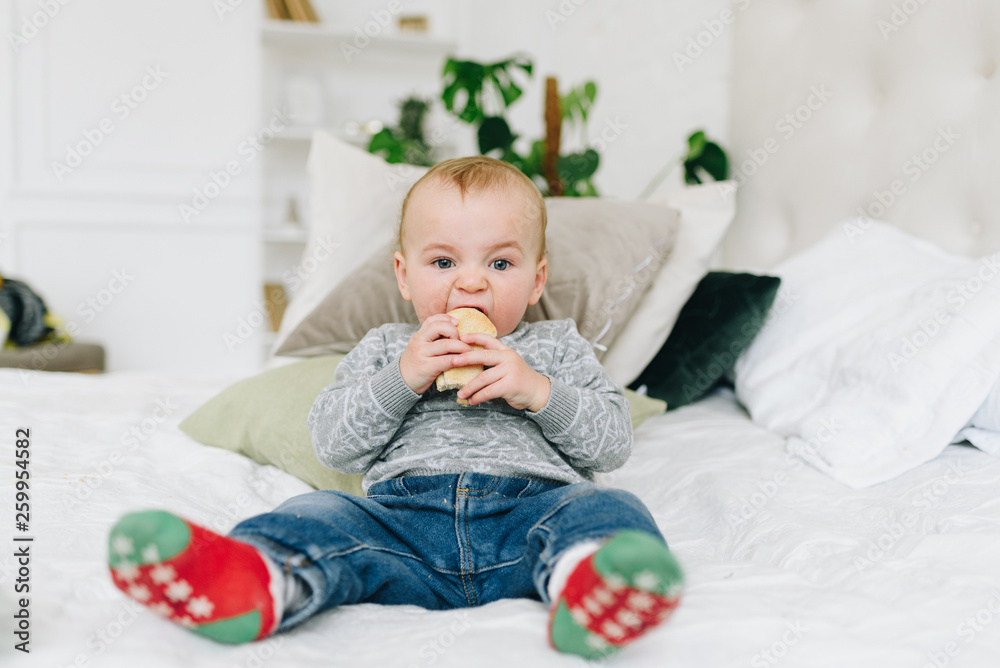 Very cute little toddler boy snacking. Baby or small child eating a piece of bread. Making funny silly face. Very cute little toddler boy snacking. Baby or small child eating a piece of bread. Making funny silly face.