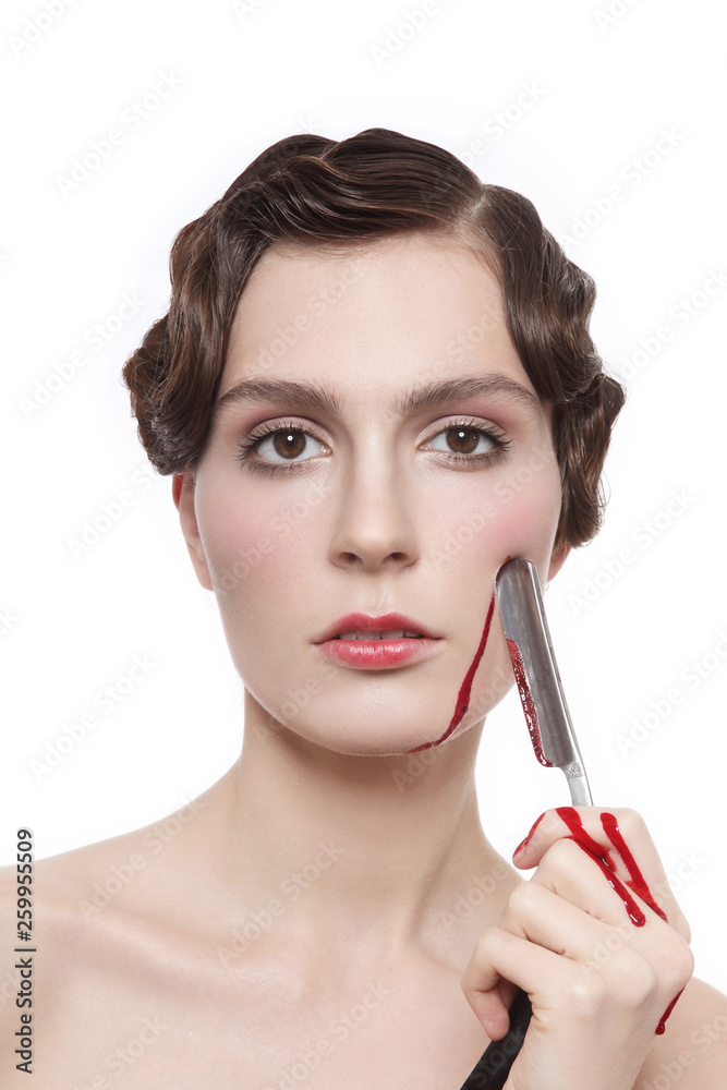 Fototapeta premium Vintage style portrait of young beautiful woman with fancy prom hairdo and bloody blade in her hand