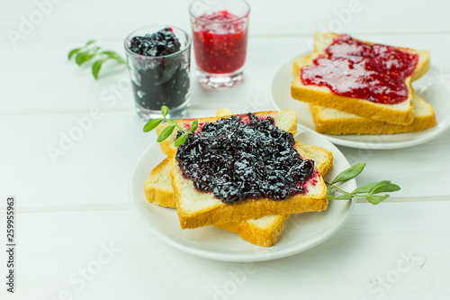 Delicious toast white bread with raspberry and currant jam on wooden table. Food,dessert, homemade food concept
