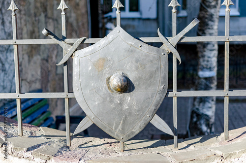 medieval knight shield and crossed swords on wooden gate shield and sword emblem on the fence